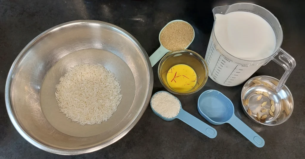 All ingredients required for kheer (rice pudding): (white rice, cane demerara sugar, saffron milk, whole milk, desiccated coconut, kewra water, rosewater, and cardamom pods)